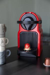 a red toaster sitting on top of a table at EMMA - Centre Historique - Parking privée - CLIM in Auch +9 photos