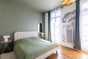 a bedroom with a bed and a large window at EMMA - Centre Historique - Parking privée - CLIM in Auch