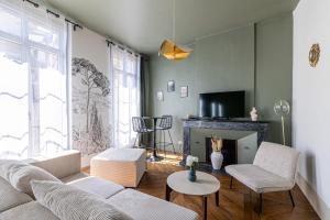 a living room with a couch and a fireplace at EMMA - Centre Historique - Parking privée - CLIM in Auch