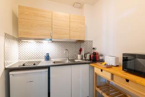 a small kitchen with a sink and a microwave at EMMA - Centre Historique - Parking privée - CLIM in Auch