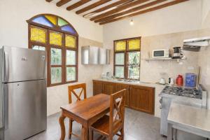 a kitchen with a wooden table and a refrigerator at Majani Breeze Zanzibar in Nungwi