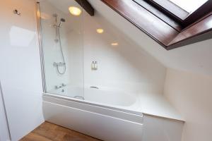 a white bathroom with a shower and a bathtub at Quarme Cottage Wheddon Cross in Wheddon Cross +92 photos
