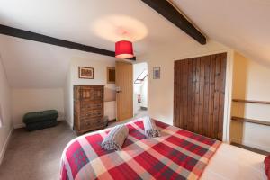 a bedroom with a bed with a colorful blanket at Quarme Cottage Wheddon Cross in Wheddon Cross