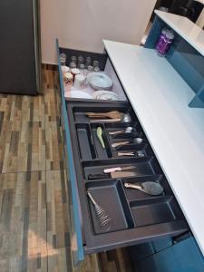 an open drawer in a kitchen counter withitems at The Riverside Nook Calicut in Kozhikode +21 photos