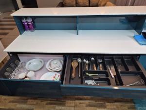 a drawer with utensils on a counter top at The Riverside Nook Calicut in Kozhikode
