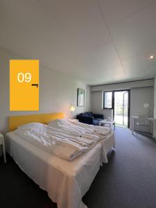 a bedroom with a large bed with an o sign on the wall at Hotel Margrethe in Gadbjerg