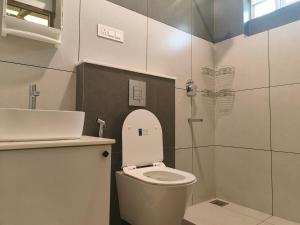 a small bathroom with a toilet and a shower at The Riverside Nook Calicut in Kozhikode