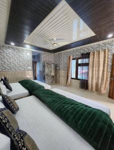 a large bed with a green cover in a room at Hotel Khetan Residency Yamunotri Dham in Kharsālī