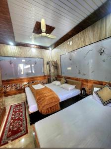 a bedroom with two beds and a ceiling at Hotel Khetan Residency Yamunotri Dham in Kharsālī