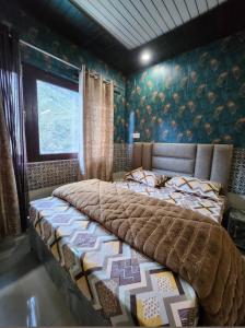 a bedroom with a large bed in a room at Hotel Khetan Residency Yamunotri Dham in Kharsālī +7 photos