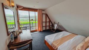 a bedroom with a bed and a desk and a window at Villa Evermist in Nuwara Eliya
