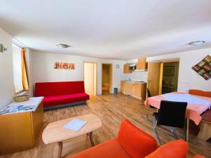 a room with two beds and a red couch at Appartement Bergschaf in Holzgau