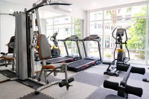 a gym with several tread machines and a large window at The Holiday Resort Pattaya in Pattaya