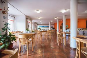 a restaurant with tables and chairs in a room at Hotel Bahia Nueva in Puerto Madryn