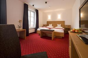 a hotel room with a bed and red carpet at Gasthof Diem in Krumbach +207 photos