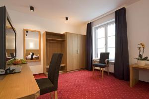 a room with a desk and chairs and a window at Gasthof Diem in Krumbach