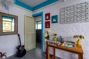 a room with a table and a guitar on the wall at The Hood Bir Billing in Bīr