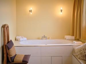 a bathroom with a large tub with a chair at Hotel Viva Sky in Konstanz +67 photos