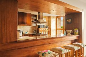 a kitchen with a counter and two stools in it at Quinta de Travanca - Casa da Eira in Baião +19 photos