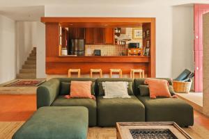 a living room with a green couch and a kitchen at Quinta de Travanca - Casa da Eira in Baião