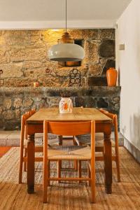 a wooden table with two chairs and a light at Quinta de Travanca - Casa da Eira in Baião