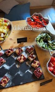 a table topped with food and bowls of fruits and vegetables at Resort Oblík - Luxusní stanové městečko in Raná +35 photos