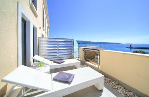 a balcony with a white table and a purple purse at Hotel Marina in Krk
