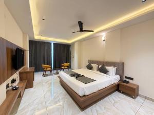 a bedroom with a bed and a television and a table at Hotel Grand Central Mysore in Mysore +39 photos