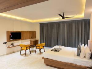 a bedroom with a bed and a table and chairs at Hotel Grand Central Mysore in Mysore