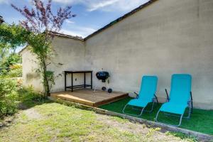 a patio with two blue chairs and a grill at Maison de charme à st émilion in Saint-Émilion
