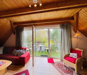 a living room with red couches and a patio at Ferienwohnung Monteurwohnung Sulingen in Sulingen