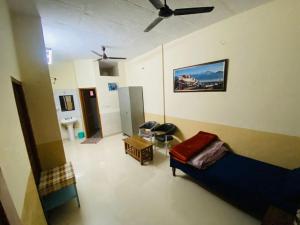 a living room with a couch and a ceiling fan at Negi Lodge Chandigarh in Chandīgarh