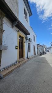a white building with a brown door on a street at Konak 83 in Nicosia