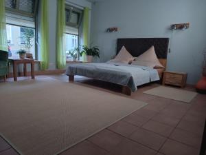 a bedroom with a bed and a table and windows at Pension am Bernsteinmuseum Ferienwohnung in Ribnitz-Damgarten