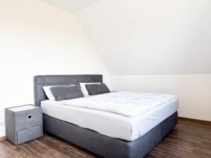 a bedroom with a large bed with a night stand at Haus Ausreißer 2 - Ankerplatz in Bensersiel