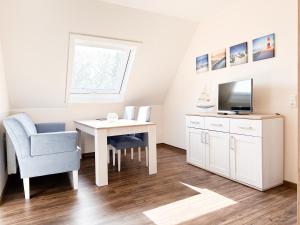 a small room with a desk and a tv and a chair at Haus Ausreißer 2 - Ankerplatz in Bensersiel