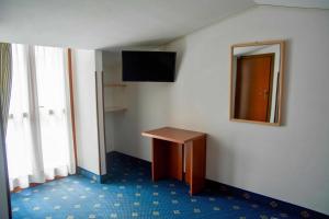 a room with a small table and a mirror at Garnì Hotel Tignale in Tignale