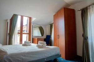 a bedroom with a bed with two towels on it at Garnì Hotel Tignale in Tignale