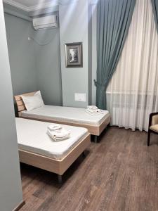 a room with two beds and a window at Гостиница Amulet in Taraz +9 photos