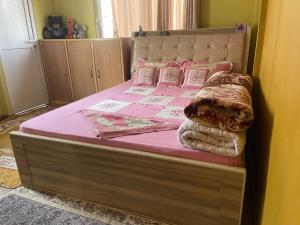 a bed with pink sheets and pillows in a bedroom at Nagdaha homestay in Pātan