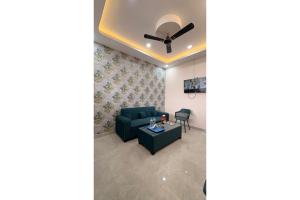 a living room with a couch and a ceiling fan at Hotel Raas Grand in Sachendi