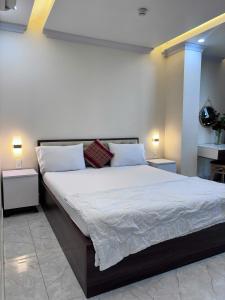 a bedroom with a large bed with white sheets and pillows at Sao Việt Nam Hotel in Ho Chi Minh City