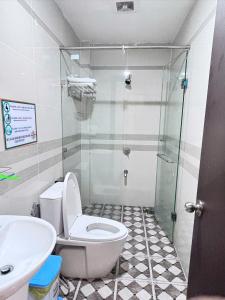 a bathroom with a toilet and a glass shower at Sao Việt Nam Hotel in Ho Chi Minh City