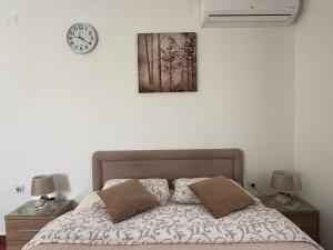 a bedroom with a bed and a clock on the wall at Milas Trojica Kotor in Kotor +32 photos