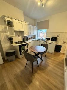 a kitchen with a table and chairs in a room at 3 Bed Near Coventry Arena, Contractor & Family Accommodation in Coventry