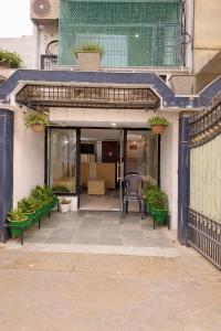a building with a patio with chairs and plants at Vrindavan Bunk Hostel by Shiva - 5min Walk from Prem Mandir in Vrindāvan
