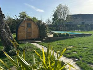 ein hölzernes Hobbit-Haus in einem Garten mit Pool in der Unterkunft Envoz-Zen in Héron + 16 Fotos