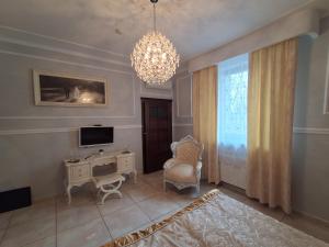 a living room with a chandelier and a desk and chair at Pensjonat Sielec in Sosnowiec