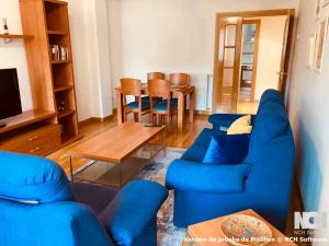 a living room with a blue couch and a table at Duque de Ahumada 8 in Soria