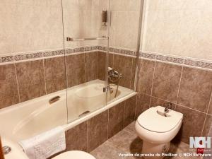 a bathroom with a toilet and a tub and a sink at Duque de Ahumada 8 in Soria +16 photos